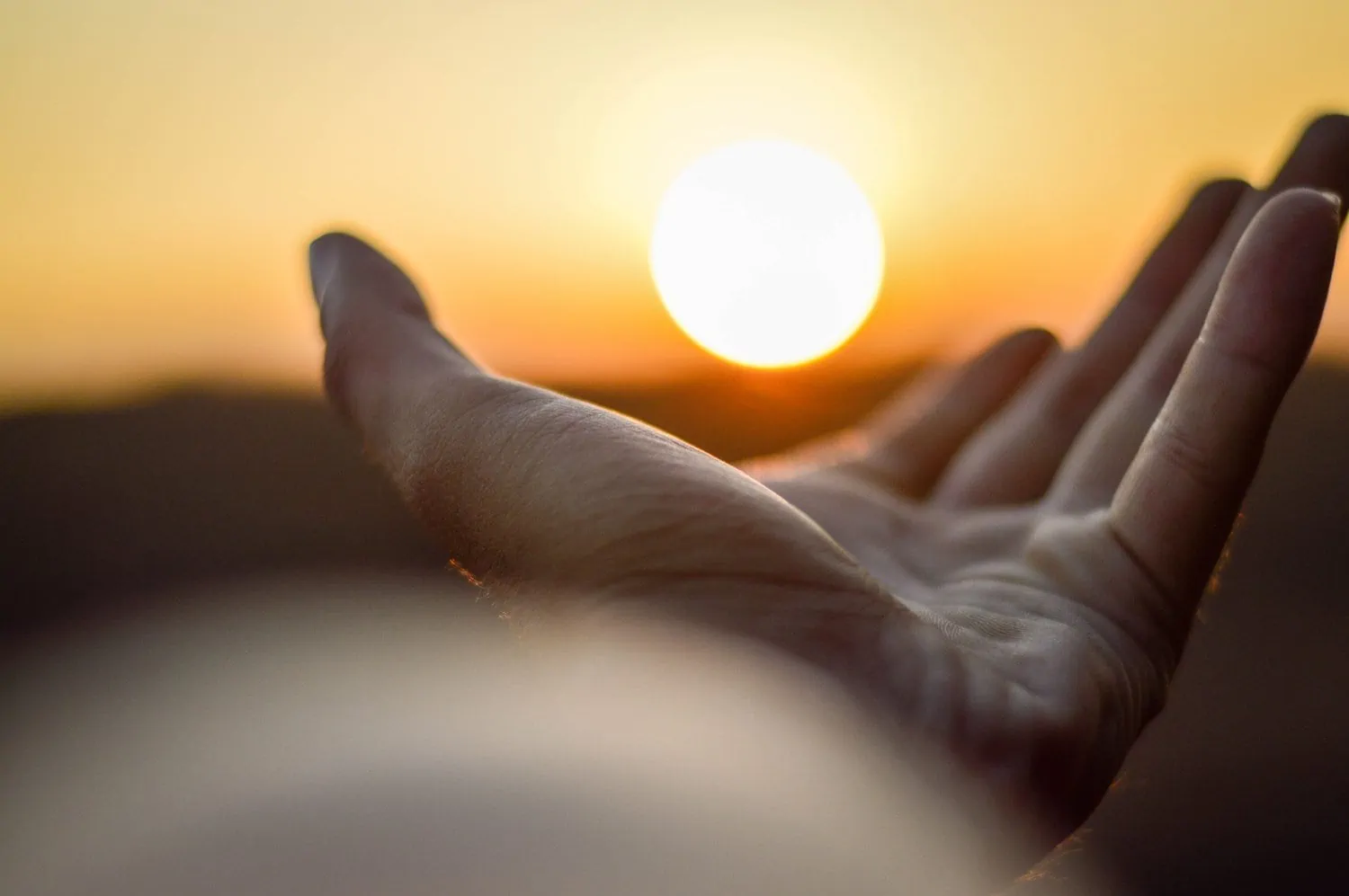 Person reaches for the sun free of worries