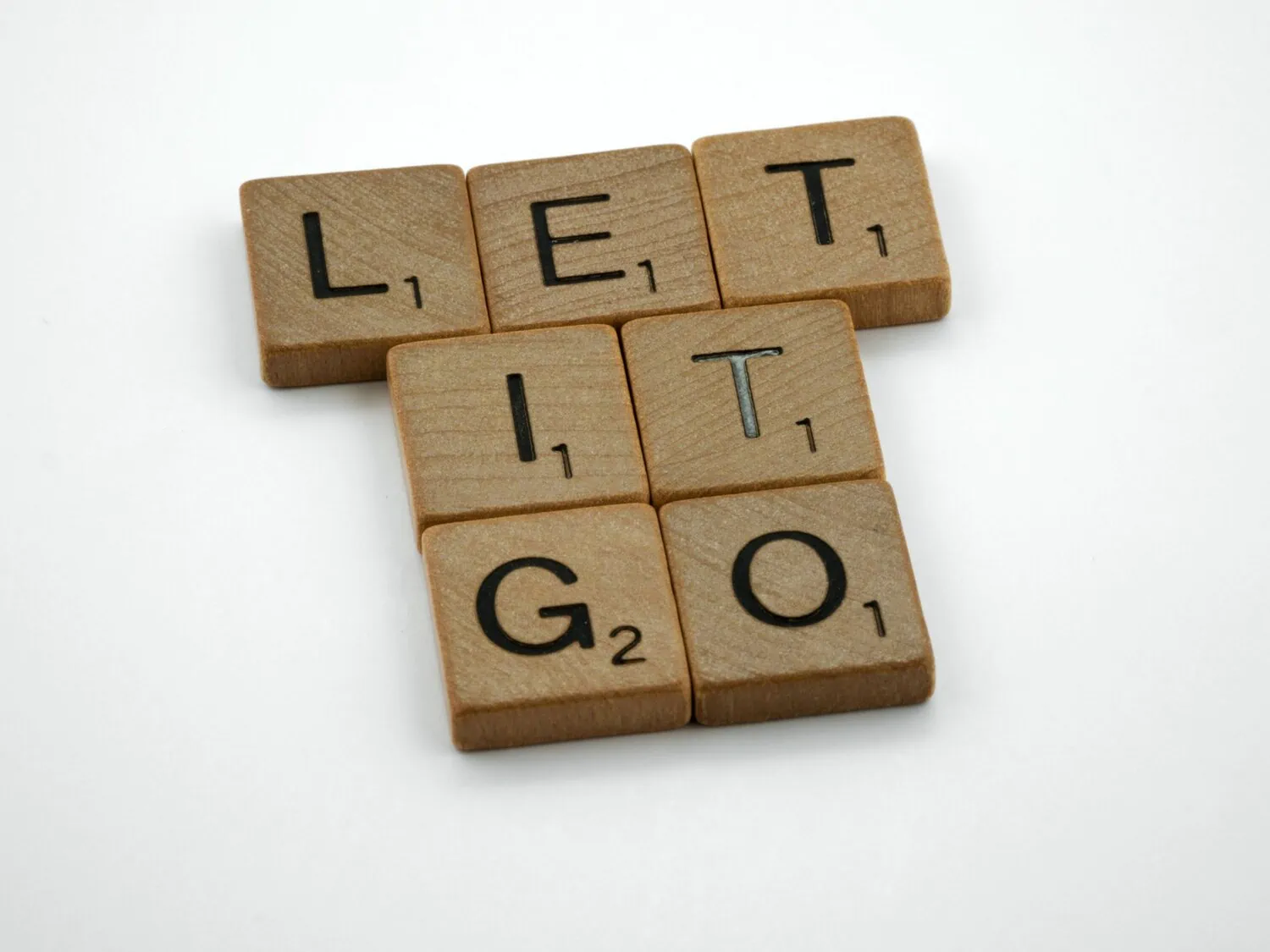 Scrabble letters spelling out let it go as a message for those wondering how to break emotional attachment to things